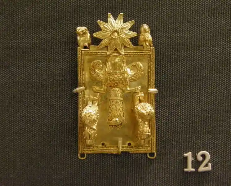 An angel and a flower on a piece of gold jewelry